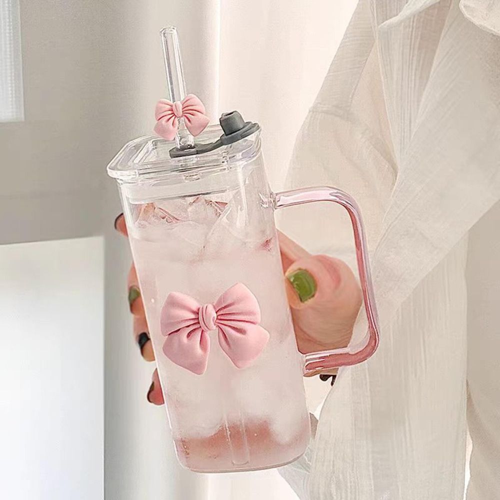 Close-up of a handled glass tumbler with lid and pink bow decoration