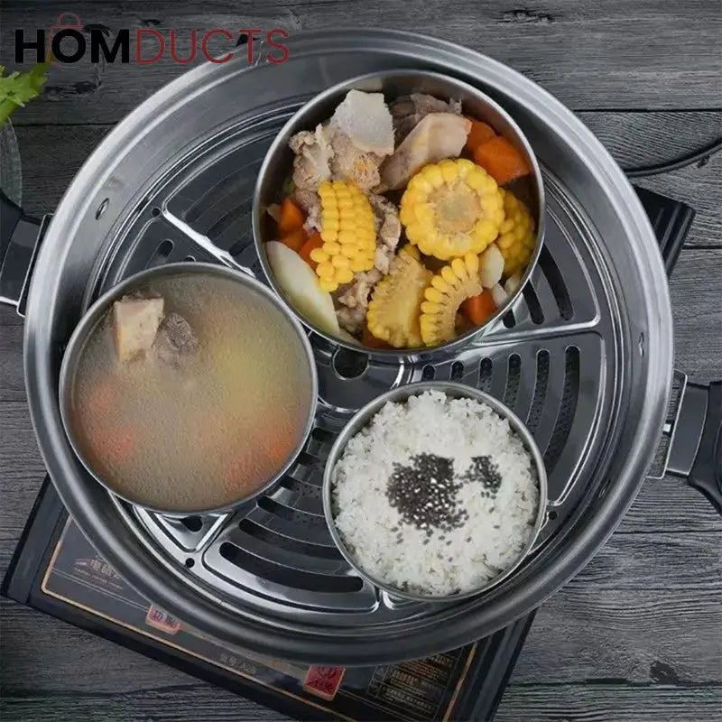 Stainless steel bowls shown holding food inside a steamer