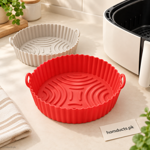 Round silicone air fryer pans with ridged bases and lifting tabs beside an air fryer