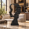 Black abstract face and stacked books sculpture