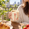 Cherry print ceramic coffee cup with fixed lid on breakfast table