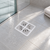 Flat disposable mesh drain cover over a bathroom drain