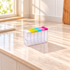 Six empty clear spice jars with colourful flip-top lids in a clear rack