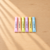 Six pastel tube-shaped SWEET DAY highlighters on a light wooden desk