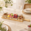 Four ceramic snack dishes on bamboo serving board