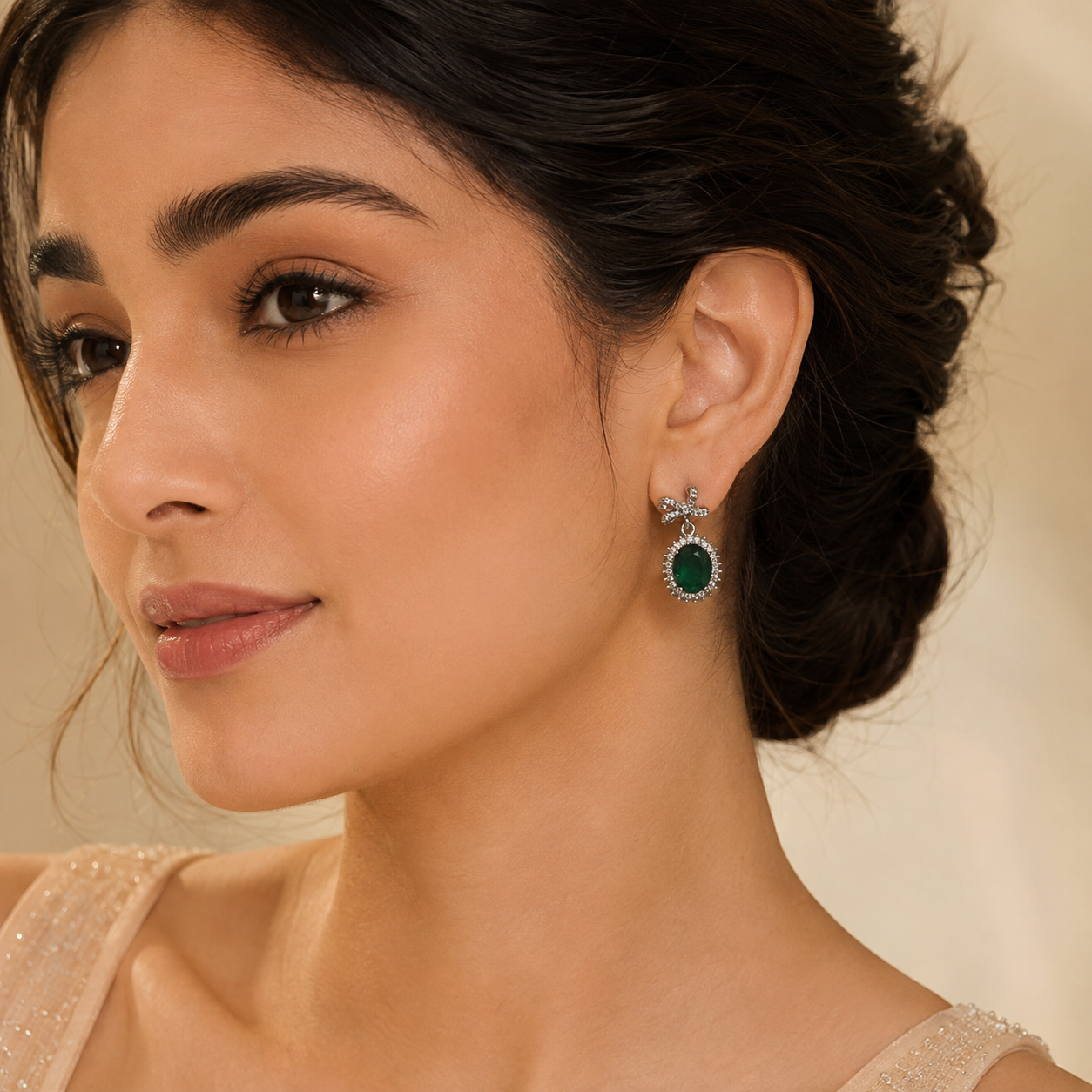 Luxury emerald green bow oval crystal drop earrings worn by a female model