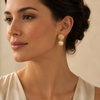 Luxury gold textured pearl drop earrings worn by a female model
