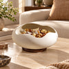 Sculptural serving bowl with wood-look base in a premium lifestyle setting